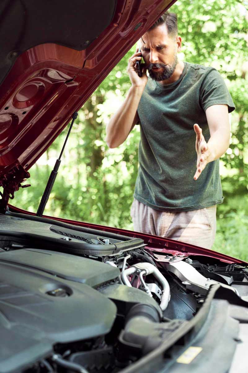 Junger Mann prüft Getriebeschaden bei Schrottauto Ankauf Wedel